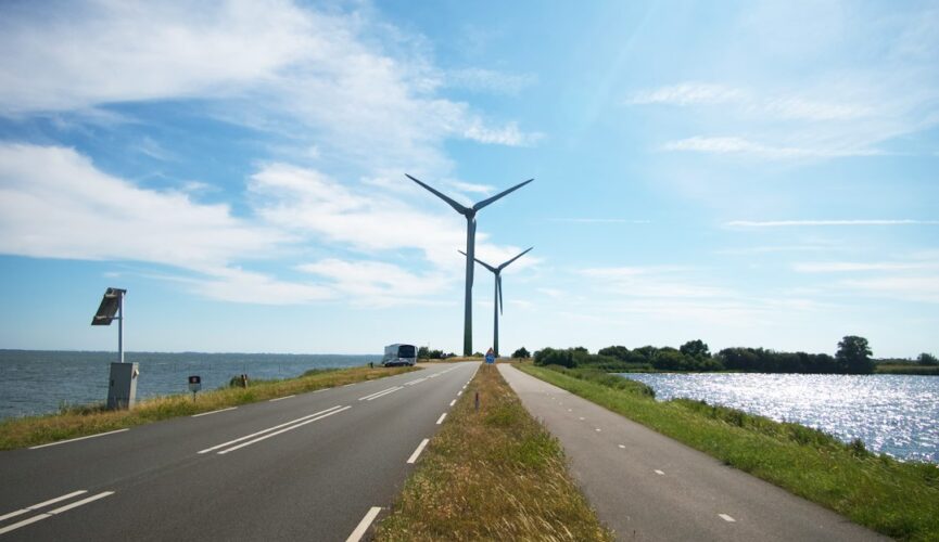 a road with a lamp post along it and a body of water in the background